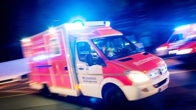 Ein Rettungswagen fährt mit Blaulicht durch eine Straße.