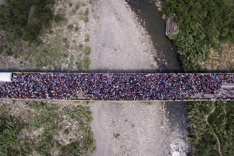 Menschen stehen auf der Brücke "Simon Bolivar" an der Grenze zwischen Venezuela und Kolumbien, nachdem die kolumbianische Regierung neue Grenzkontrollen eingeführt hat.