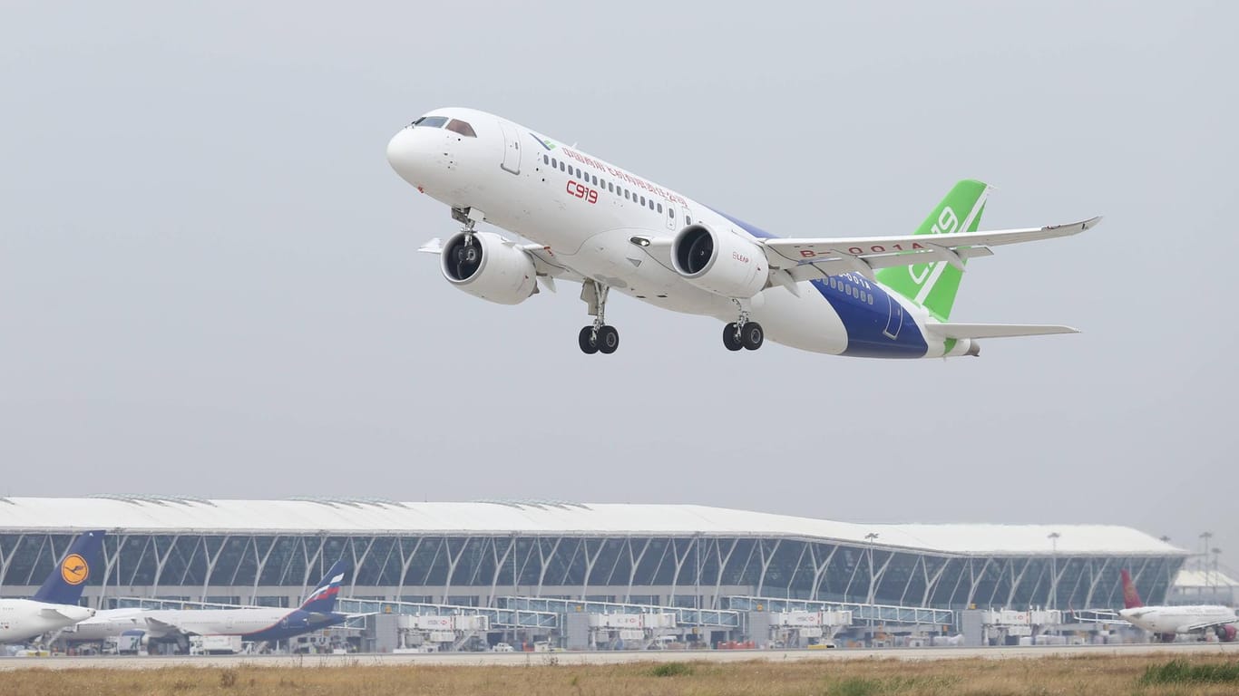 Ein Flugzeug startet vom Pudong-Flughafen in Shanghai: Im Hintergrund das Flughafengebäude.