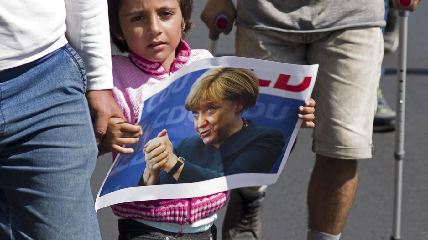 Ein junges Mädchen mit einem Merkel-Plakat im Septmeber 2015 in Budapest: Man stelle sich vor, Merkel hätte damals gesagt: "Wir schaffen das nicht."