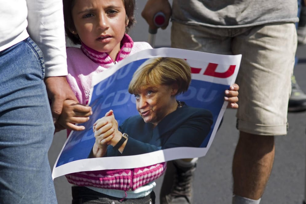Ein junges Mädchen mit einem Merkel-Plakat im Septmeber 2015 in Budapest: Man stelle sich vor, Merkel hätte damals gesagt: "Wir schaffen das nicht."