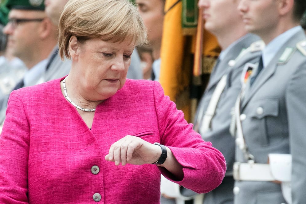 Angela Merkel wirft einen Blick auf die Uhr: Die Abschaffung der Zeitumstellung stößt auch bei der Kanzlerin auf Zustimmung.