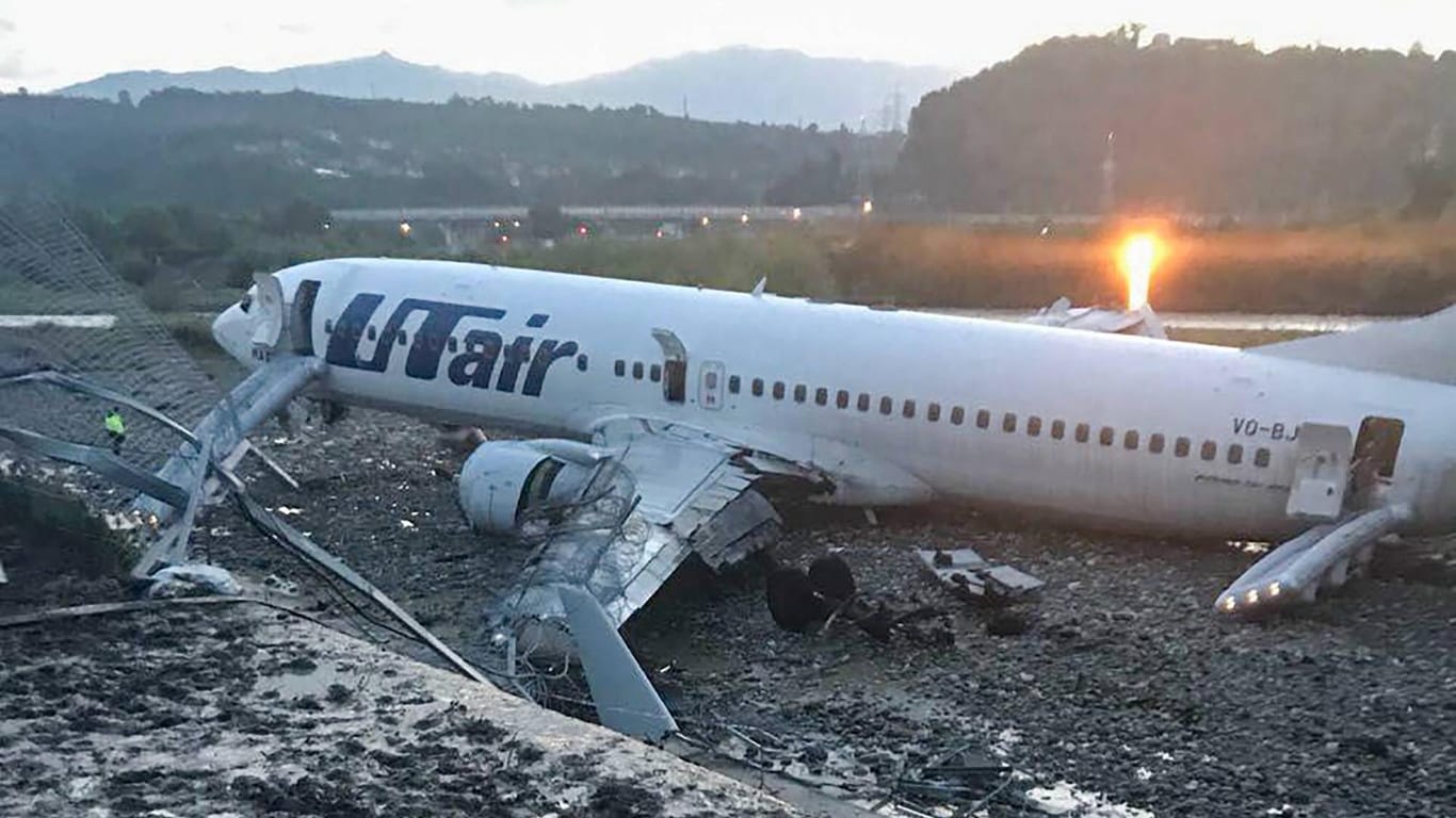 Ein Flugzeug der Fluggesellschaft UTair vom Typ Boeing 737-800 liegt nach einer Bruchlandung neben der Rollbahn: Ein Flughafenangestellter sei an Herzversagen gestorben, während er den Passagieren beim Verlassen des Jets über die Notrutschen half.