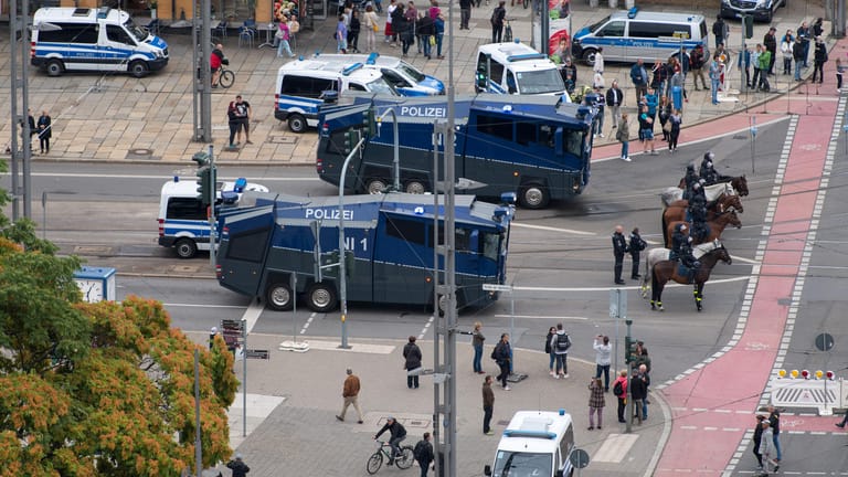 Polizeiautos, Wasserwerfer und eine Reiterstaffel der Polizei stehen in Bereitschaft in Chemnitz.