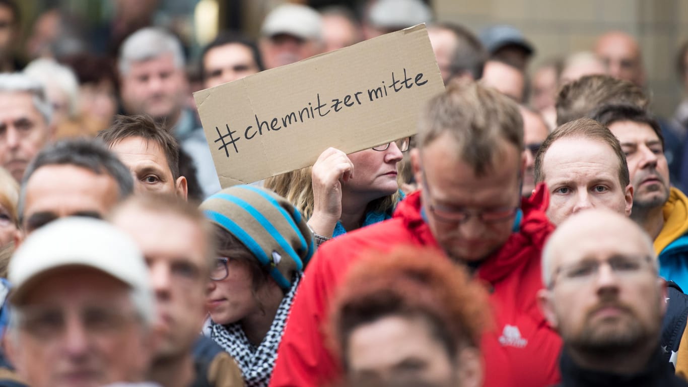 Sachsen, Chemnitz: Eine Teilnehmerin der Kundgebung der Evangelisch-Lutherischen Kirche Chemnitz unter dem Motto "Wir in Chemnitz · aufeinander hören, miteinander handeln" hält ein Schild mit der Aufschrift "hält ein Pappschild mit der Aufschrift "#chemnitzermitte" hoch.