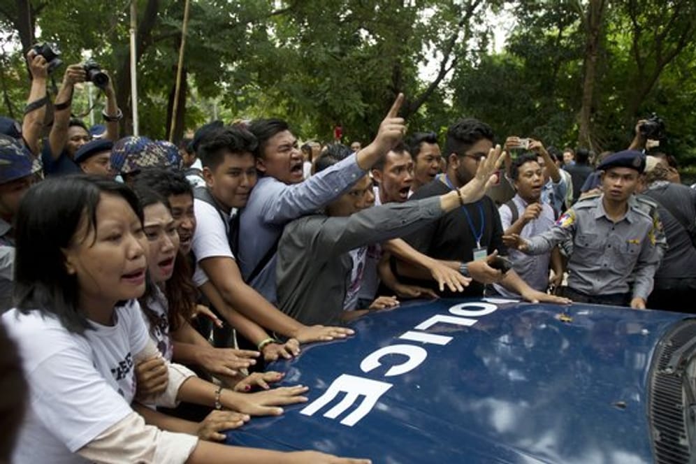 Journalisten und Aktivisten versuchen ein Polizeiauto zu blockieren, in dem die beiden verurteilten Reuters Journalisten sitzen.