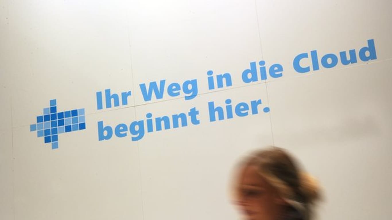 Eine Frau geht an einem Werbeslogan der Firma Microsoft zum Cloud Computing auf dem Messegelände in Hannover vorbei.