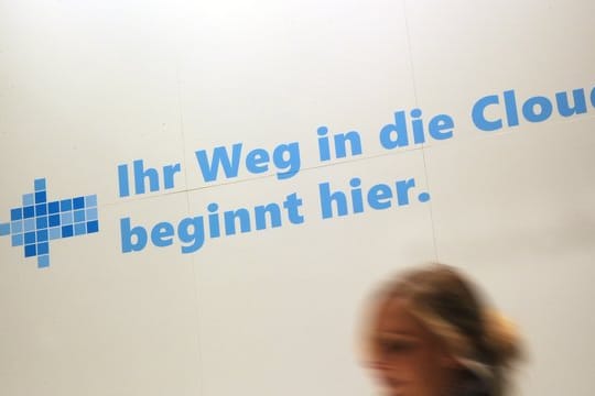 Eine Frau geht an einem Werbeslogan der Firma Microsoft zum Cloud Computing auf dem Messegelände in Hannover vorbei.