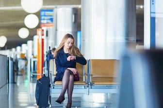 Frau wartet ungeduldig am Flughafen: Welche Fluggastrechte gelten bei Streiks, die anschließend zum Ausfall oder zur Verspätung von Flügen führen?