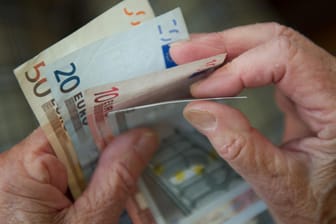 Eine ältere Frau zählt Geld: Rentner, die ihre Beiträge zu einer betrieblichen Altersvorsorge in Teilen oder ganz aus eigener Tasche gezahlt haben, können die darauf entfallenen Beiträge zur Kranken- und Pflegeversicherung zurückfordern.