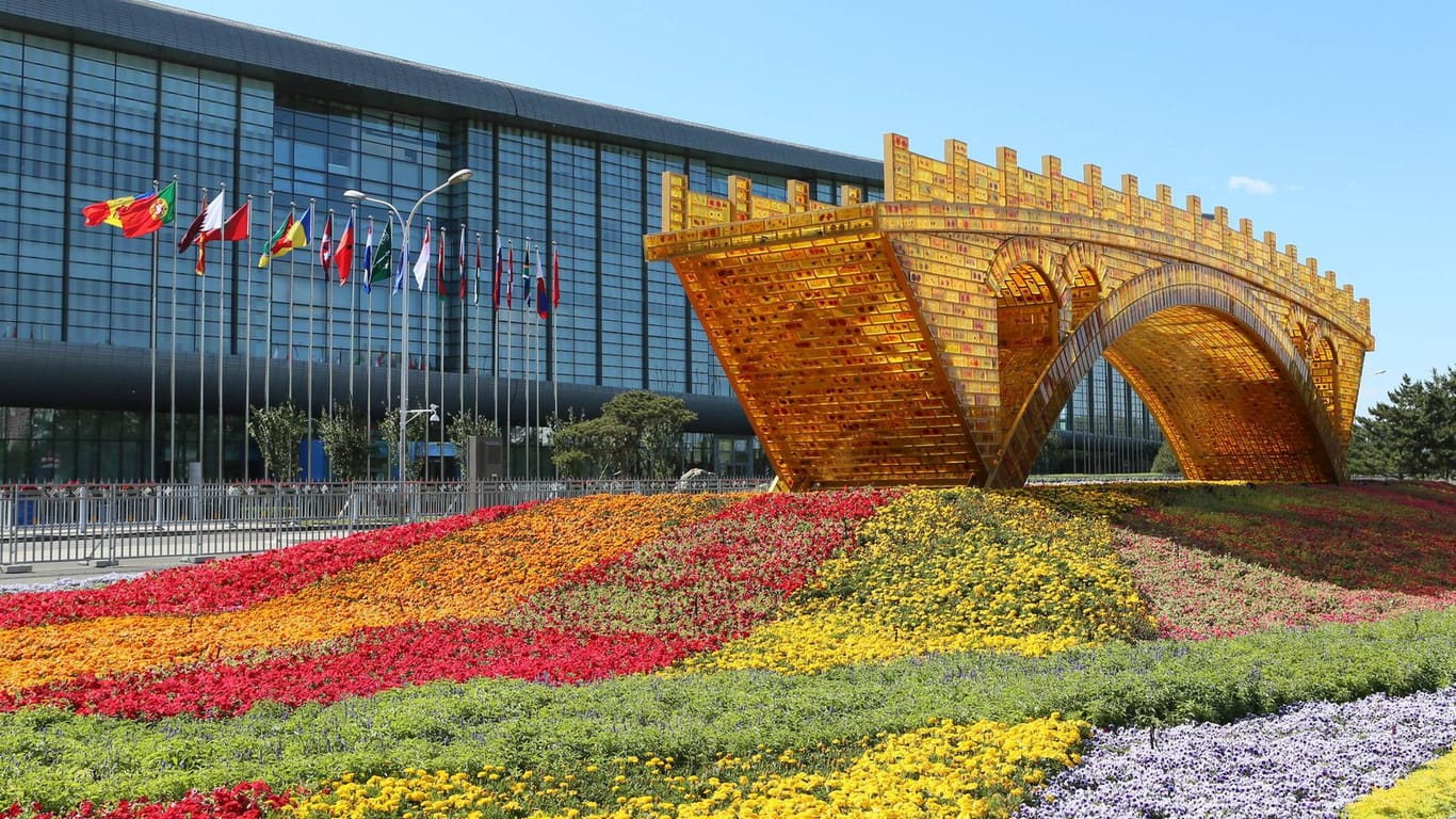 Das National Convention Center in Beijing: Vor dem Gebäude steht eine goldene Brücke, die Chinas Prestigeprojekt, die "Neue Seidenstraße", repräsentieren soll.