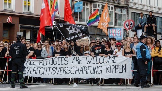 Demonstranten protestieren gegen eine "Merkel muss weg!"-Veranstaltung auf dem Gänsemarkt in Hamburg. Demonstranten protestieren gegen eine "Merkel muss weg!"-Veranstaltung auf dem Gänsemarkt in Hamburg.
