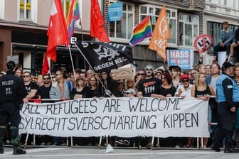 Demonstranten protestieren gegen eine "Merkel muss weg!"-Veranstaltung auf dem Gänsemarkt in Hamburg.