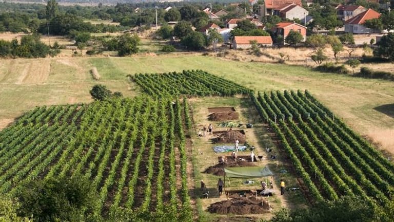 Die archäologische Fundstätte von Pokrovnik während der Aushöhlung mit dem modernen Dorf (r).
