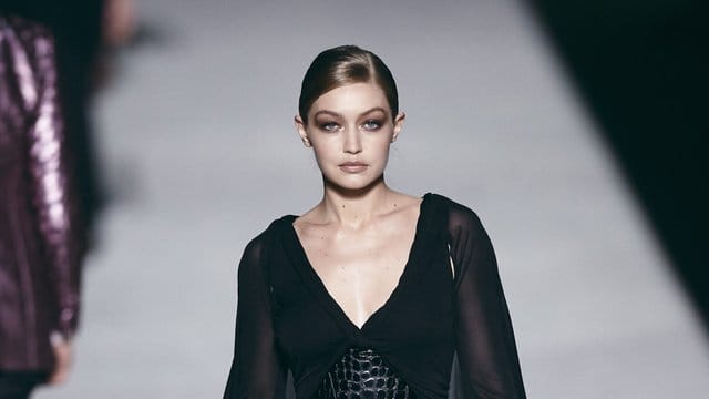 Ganz in Schwarz mit einem hauchdünnen Cape: Supermodel Gigi Hadid präsentiert eine Kreation von Tom Ford. Ganz in Schwarz mit einem hauchdünnen Cape: Supermodel Gigi Hadid präsentiert eine Kreation von Tom Ford.