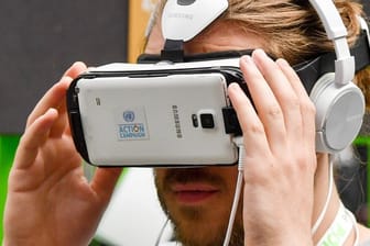 Ein Besucher der Internetkonferenz re:publica schaut im Mai in eine an ein Smartphone montierte VR-Brille.