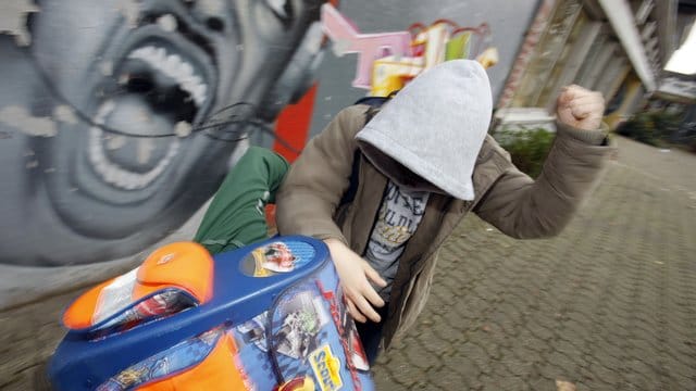 Zwei Schüler prügeln sich auf einem Schulhof.