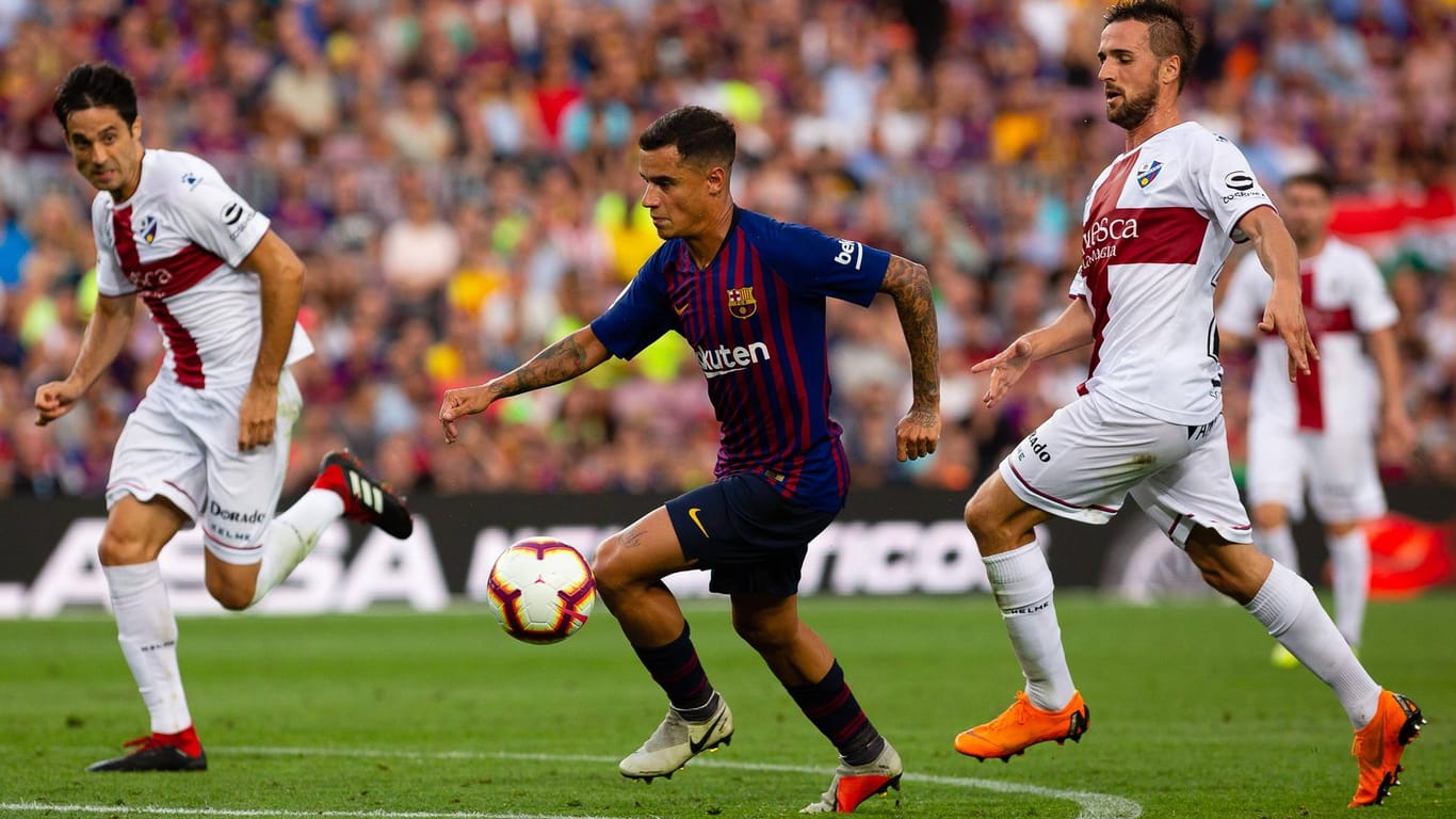 Spielszene: Barcelonas Coutinho (M.) setzt sich gegen die Huesa-Abwehr durch.