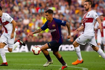 Spielszene: Barcelonas Coutinho (M.) setzt sich gegen die Huesa-Abwehr durch.