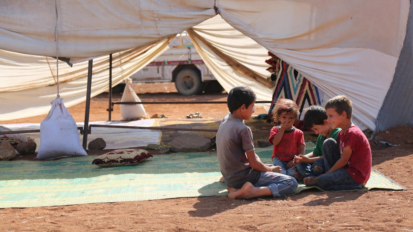 Kinder sitzen vor ihrem Zelt in einem provisorischen Flüchtlingslager: Die Flüchtlinge mussten wegen andauernder Angriffe einige Flüchtlingslager in der Provinz Idlib verlassen.