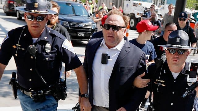 Juli 2016: Alex Jones wird von Polizisten aus einer Gruppe von Demonstranten weggeführt.