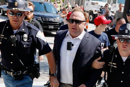 Juli 2016: Alex Jones wird von Polizisten aus einer Gruppe von Demonstranten weggeführt.