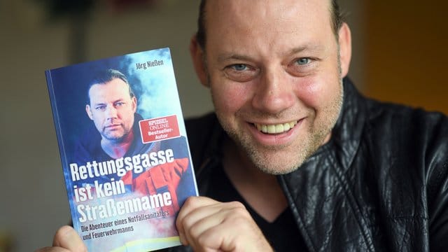 Der Autor Jörg Nießen mit seinem Buch "Rettungsgasse ist kein Straßenname".