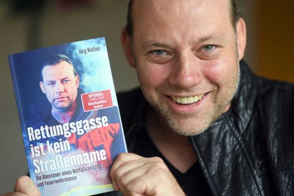 Der Autor Jörg Nießen mit seinem Buch "Rettungsgasse ist kein Straßenname".