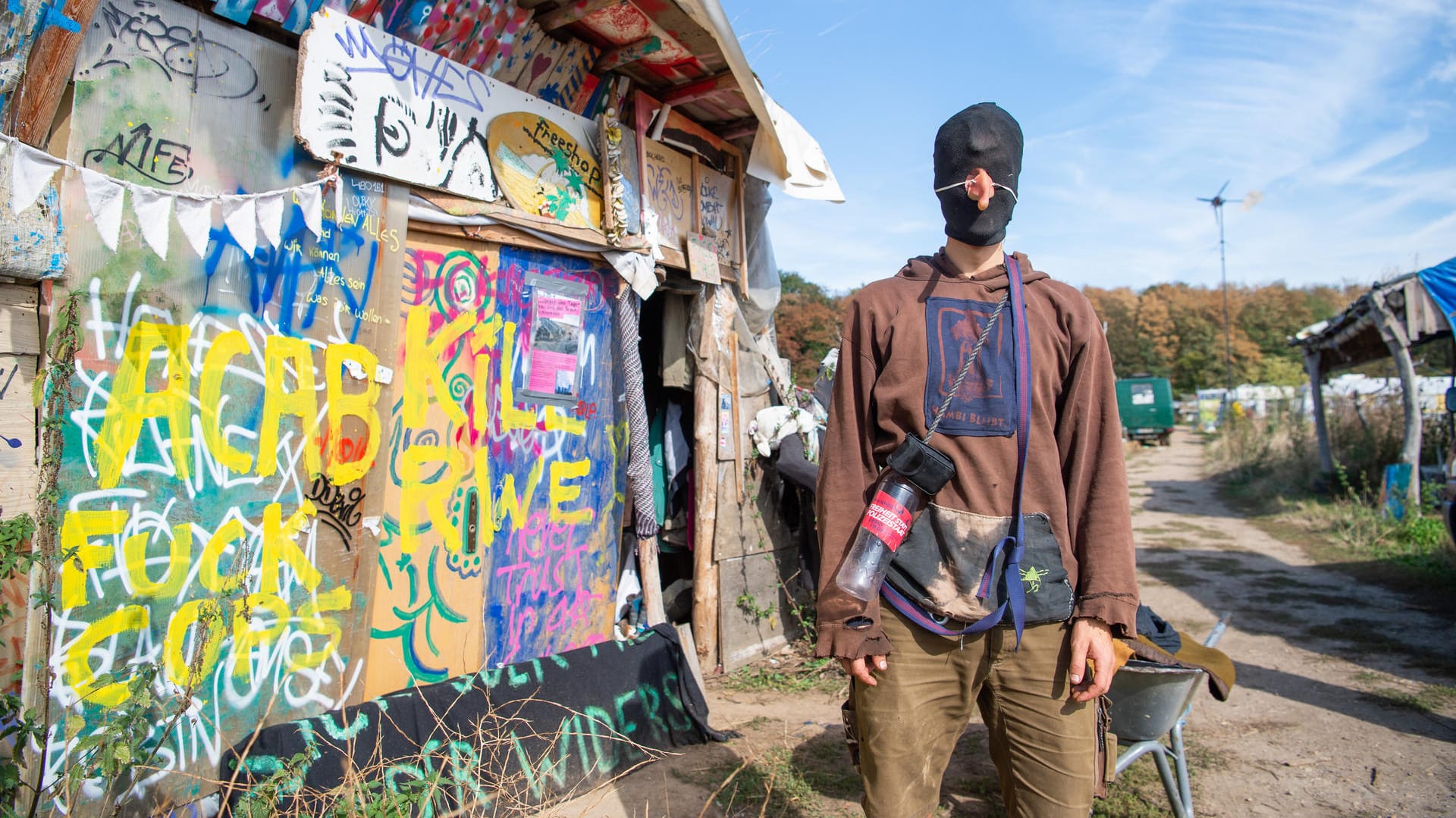 Ein vermummter Umweltaktivist mit einer Gumminase steht in einem Camp von Umweltaktivisten am Hambacher Forst.