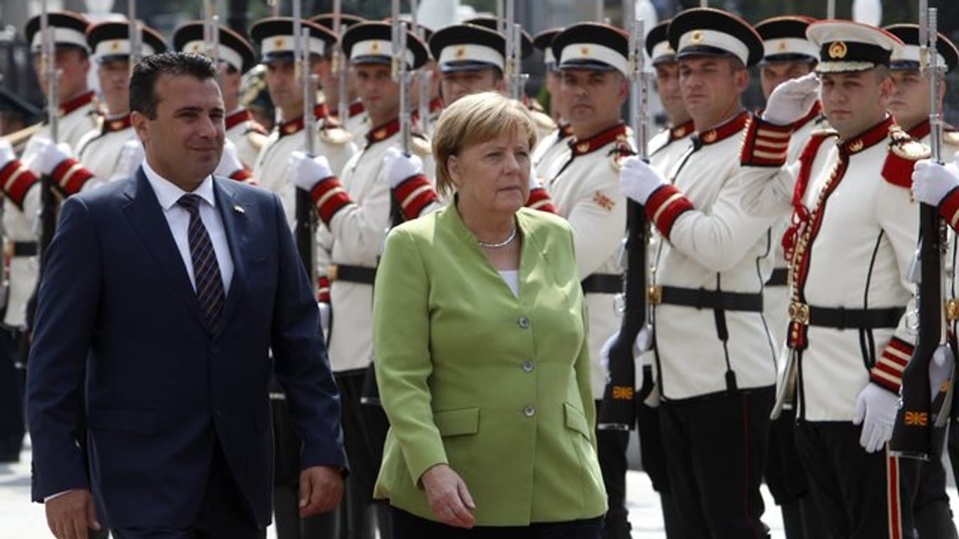 Kanzlerin Angela Merkel und der mazedonische Ministerpräsident Zoran Zaev (l) schreiten nach Merkels Ankunft die Ehrengarde ab.