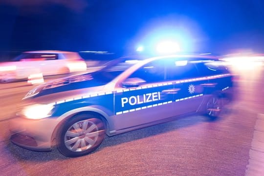 Ein Polizeifahrzeug steht mit Blaulicht auf der Straße. (Symbolbild)