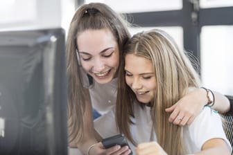 Zwei Jugendliche mit einem Smartphone: Das Chat-Portal knuddels.de wird vor allem von Jugendlichen genutzt.