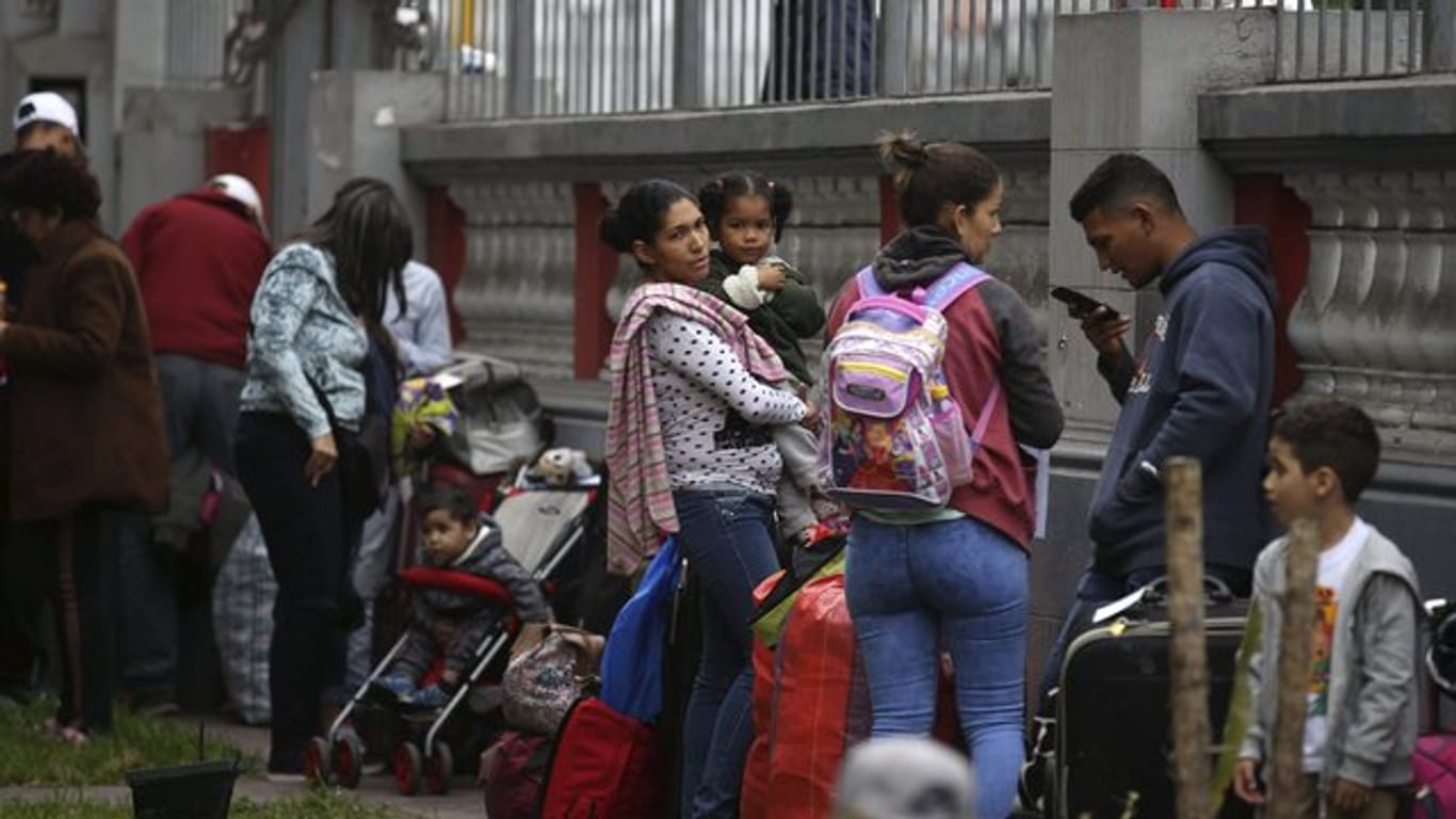 Venezolanische Migranten warten auf dem Gelände der Botschaft ihres Landes auf einen Bus, der sie zum Flughafen bringt.