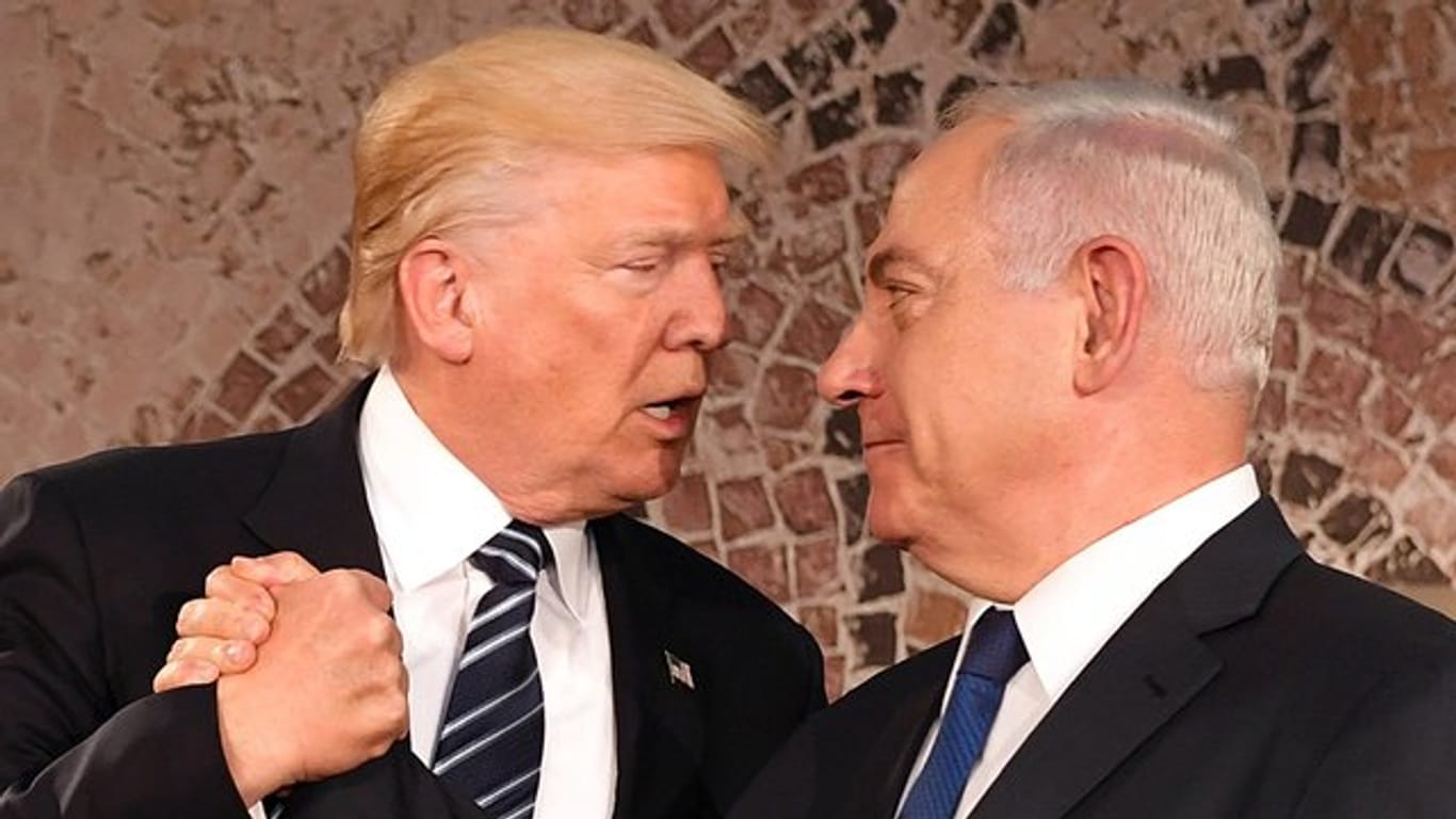 Der israelische Ministerpräsident Benjamin Netanjahu (r) und US-Präsident Donald Trump geben sich die Hand.