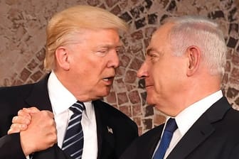 Der israelische Ministerpräsident Benjamin Netanjahu (r) und US-Präsident Donald Trump geben sich die Hand.