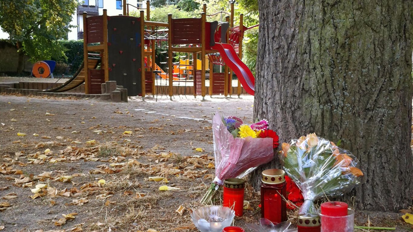 Passanten haben Kerzen und Blumen vor einem Spielplatz in Köthen abgelegt: Hier wurde der 22-Jährige tödlich verletzt.