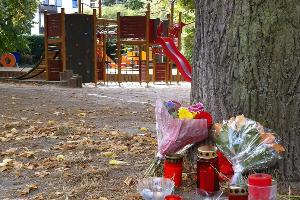 Passanten haben Kerzen und Blumen vor einem Spielplatz in Köthen abgelegt: Hier wurde der 22-Jährige tödlich verletzt.