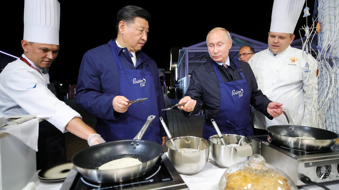 Russlands Wladimir Putin und Chinas Xi Jinping stehen in Wladivostok in Kochschürzen vorm Herd: Russland und China beraten über eine engere Zusammenarbeit, auch im militärischem Bereich.