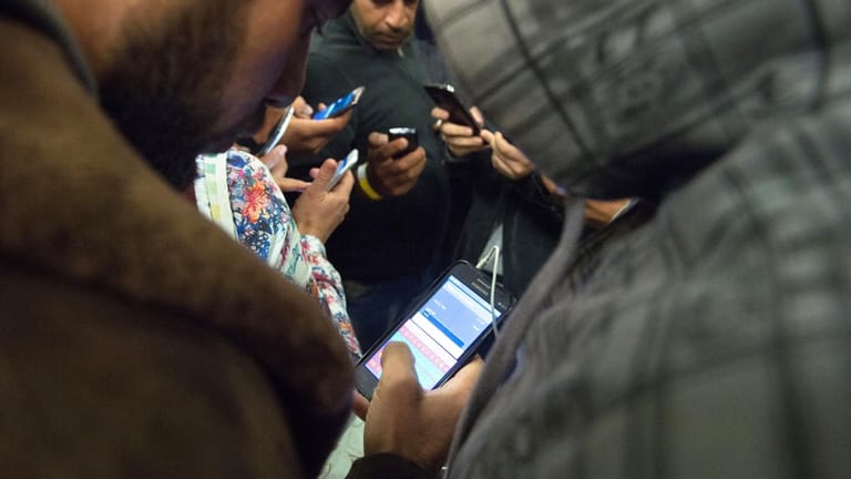 Flüchtlinge mit Smartphones.