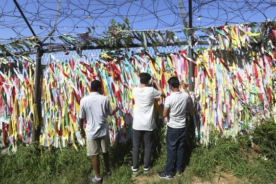 Menschen hängen Spruchbänder mit dem Wunsch zur Wiedervereinigung zwischen Nord- und Südkorea nahe der Grenze zu Nordkorea auf.