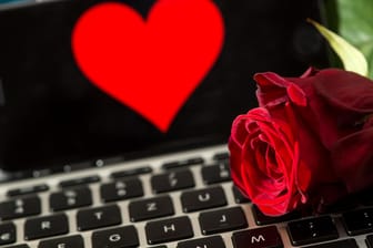 Eine Rose liegt auf einer Tastatur: In München beginnt am 13.09.2018 ein Prozess um Abzocke beim Online-Dating