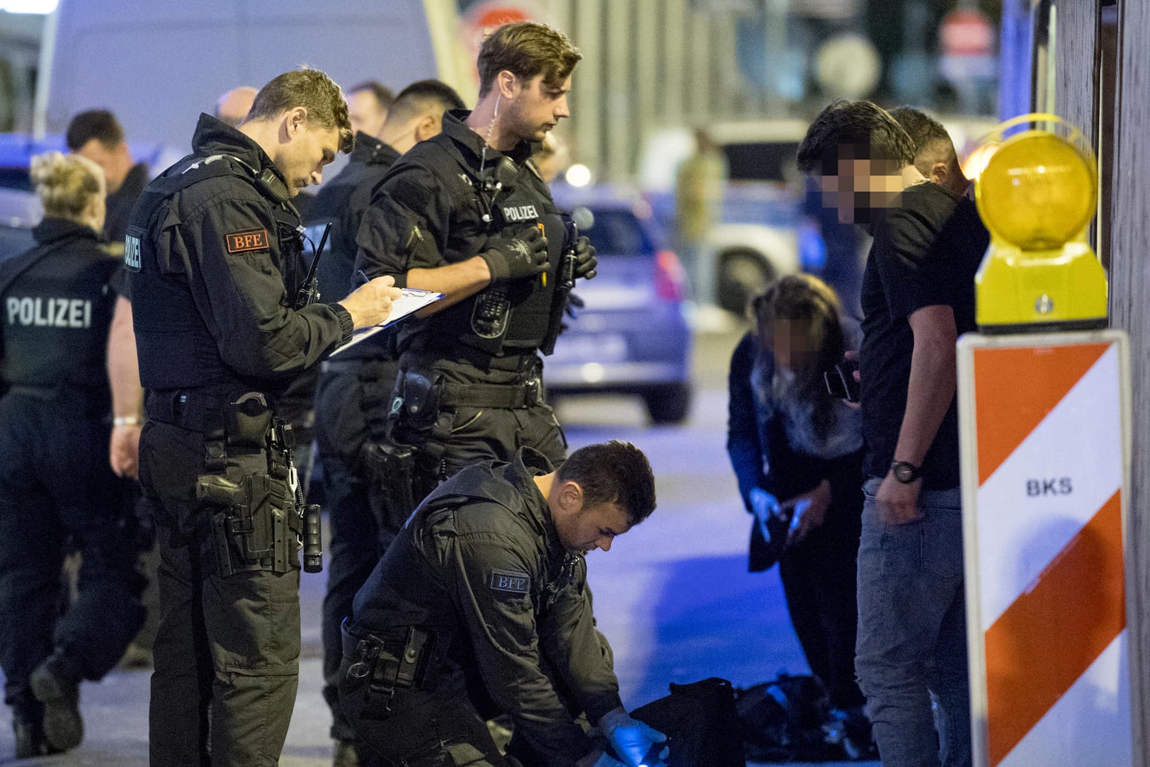 Ein Polizist durchsucht den Rucksack eines Mannes nach Drogen: Bei der nach Polizeiangaben bislang größten Razzia im Bahnhofsviertel waren rund 500 Beamte im Einsatz.