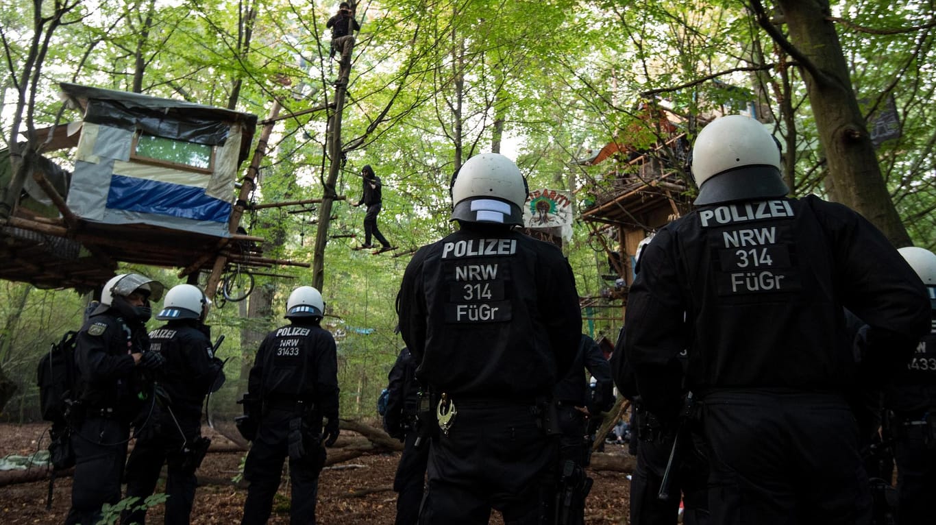 Polizisten stehen im Hambacher Forst unter Baumhäusern: Der nordrhein-westfälische Innenminister Herbert Reul hat die Räumung verteidigt.