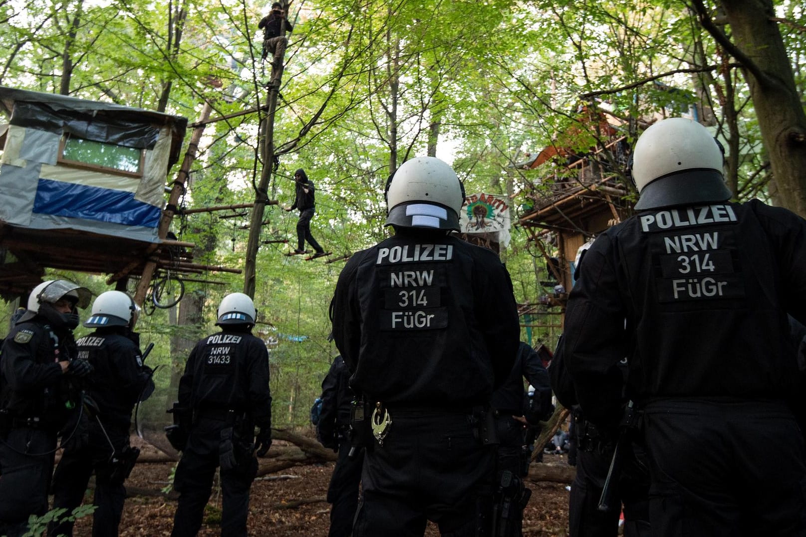 Polizisten stehen im Hambacher Forst unter Baumhäusern: Der nordrhein-westfälische Innenminister Herbert Reul hat die Räumung verteidigt.