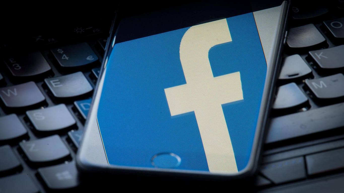 Das Facebook-Logo spiegelt sich auf einem Smartphone-Bildschirm: Das Netzwerk will künftig auch Videos und Bilder einem Faktencheck unterziehen.