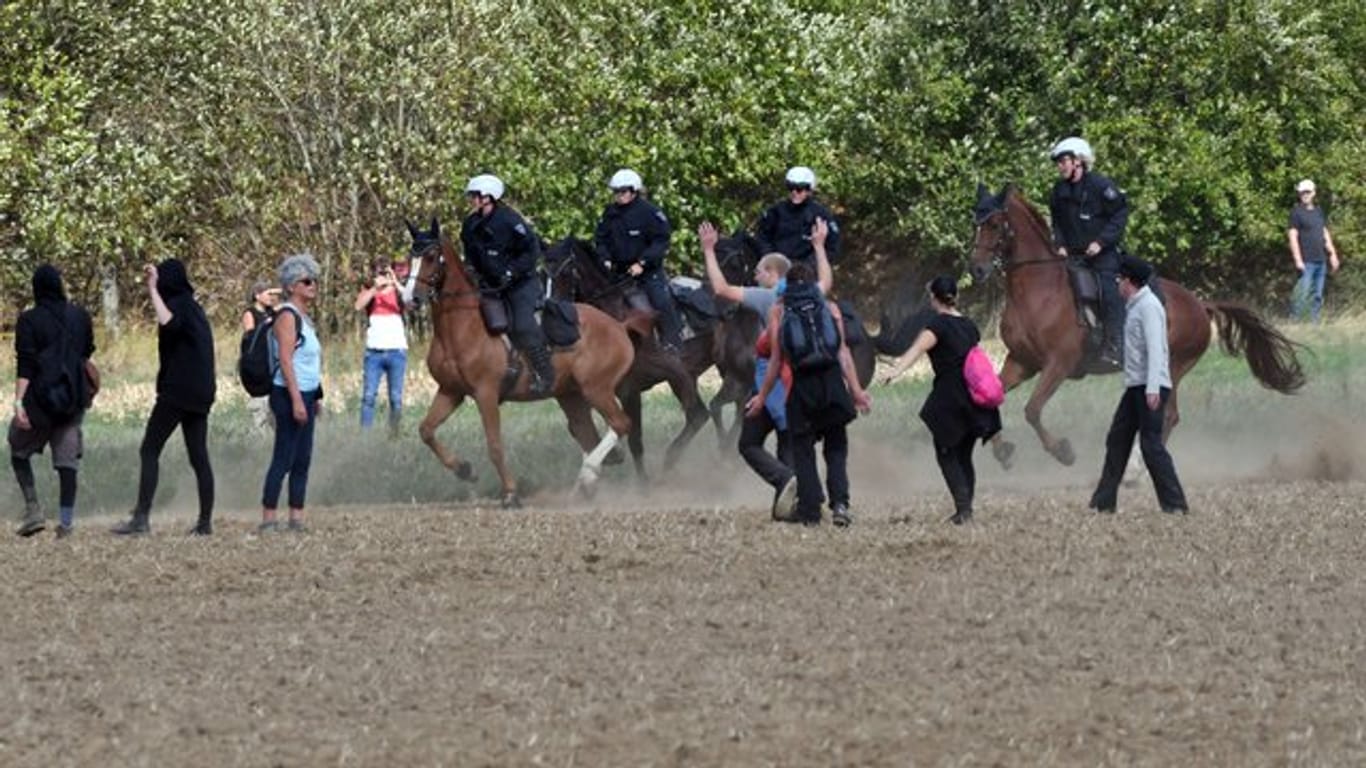Polizisten auf Pferden versuchen, Demonstranten davon abzuhalten, in den "Hambacher Forst" einzudringen.