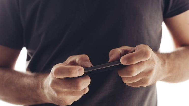 Ein Mann spielt auf seinem Smartphone (Symbolbild): Das Spiel "Battue 8192" verspricht eine Millionen Euro Preisgeld.