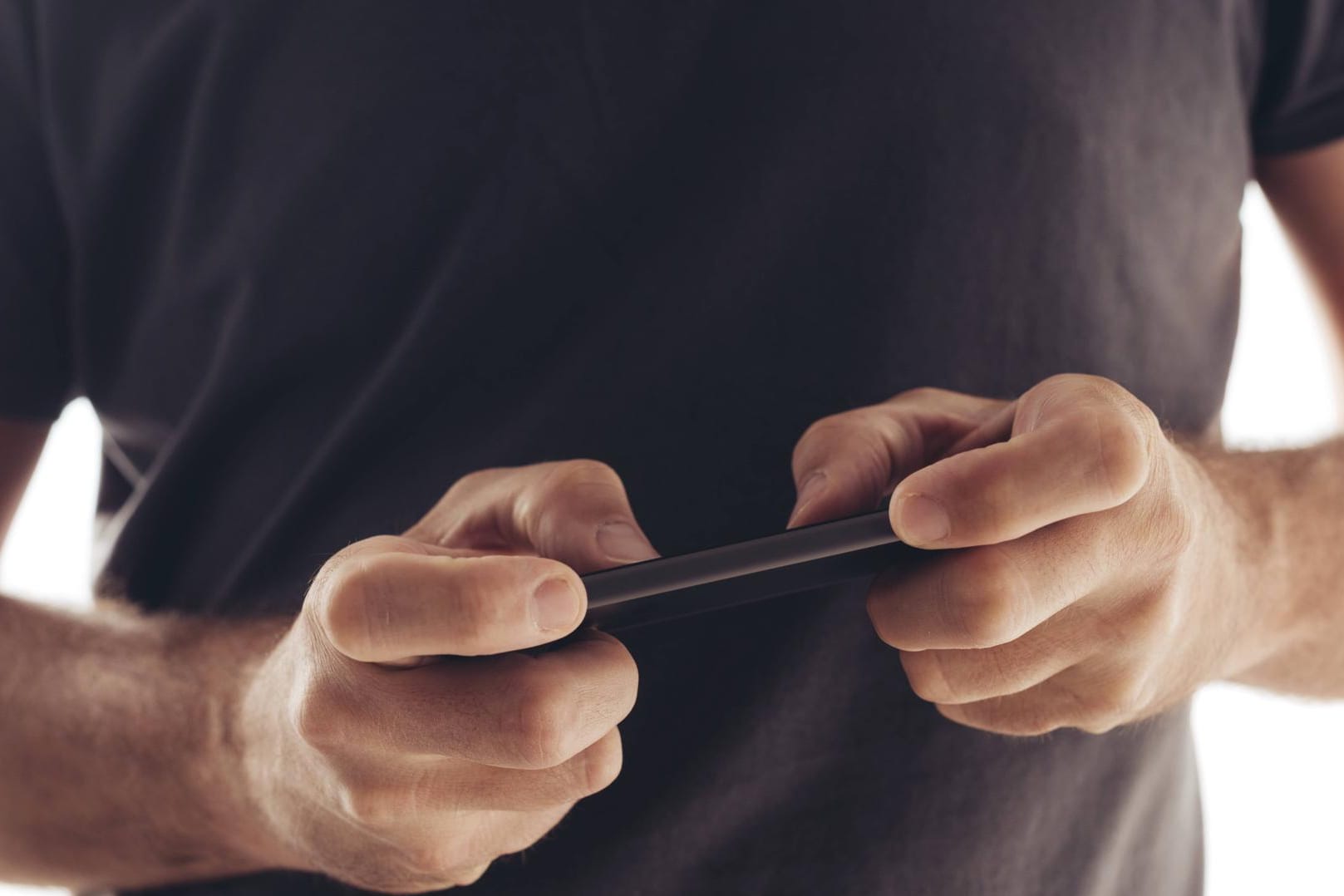 Ein Mann spielt auf seinem Smartphone (Symbolbild): Das Spiel "Battue 8192" verspricht eine Millionen Euro Preisgeld.