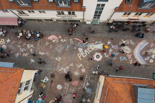 Mit Malkreide haben viele Bürgerinnen und Bürger Botschaften auf den Boden einer Straße in der Nähe des Marktplatzes gemalt und geschrieben.