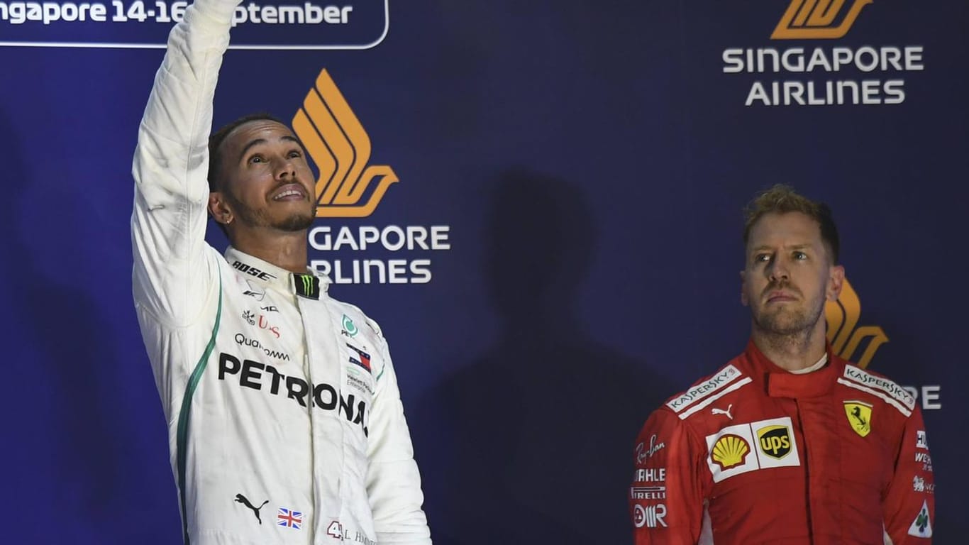 Auf dem Podium in Singapur: Lewis Hamilton (links) feiert seinen siebten Saisonsieg, Sebastian Vettel ist entsprechend niedergeschlagen.